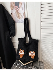 Detail of black faux fur tote bag featuring two 3D plush cat charms on soft furry material