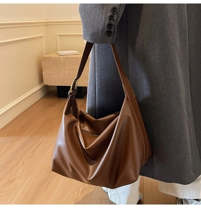 Brown matte faux leather tote bag with wide shoulder strap showing large capacity