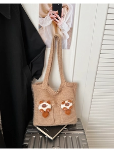 Detail of khaki knit tote bag featuring cute animal plush toys and thick woven texture