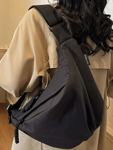Stylish large black crescent crossbody bag for women featuring a wide woven shoulder strap