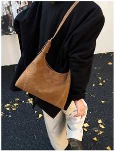 Brown suede hobo bag featuring contrast white stitching and gold logo details