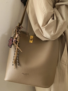 Sac seau minimaliste en cuir kaki avec fermoir métallique et breloque ours