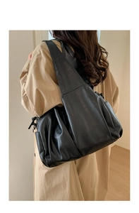 Vue détaillée du sac cabas plissé noir montrant la poche latérale et le cuir souple