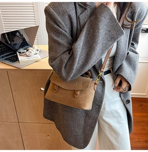 Close-up of brown vintage leather crossbody bag worn by model in a cozy indoor setting
