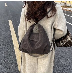 Détail d'un sac à dos hobo vintage en cuir mat souple sur mannequin en extérieur