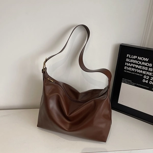 Detail view of large brown faux leather tote bag with adjustable strap and gold hardware