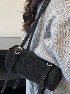 Minimalist black cylinder shoulder bag in vintage leather with adjustable straps