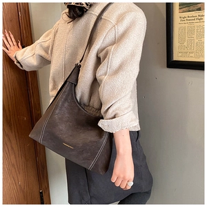 Detail of dark brown vintage hobo bag with contrast white stitching and gold lettering