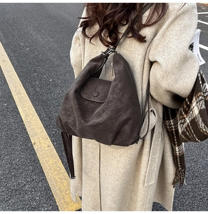 Détail du sac hobo marron foncé en daim synthétique vintage montrant la texture et le zip