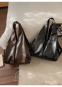 Détail de grands sacs cabas en cuir souple disponibles en marron foncé et noir chic