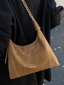 Brown suede underarm tote bag with gold chain strap and decorative white contrast stitching