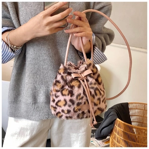 Close-up of leopard print faux fur bucket bag with pink leather bow and drawstring