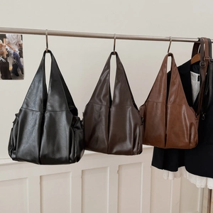 Sacs cabas vintage minimalistes en noir, café et caramel sur un support d'exposition
