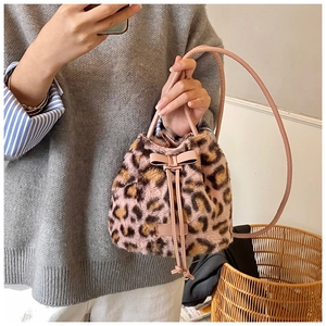 Detail of pink leopard faux fur bucket bag featuring a decorative leather bow and drawstring
