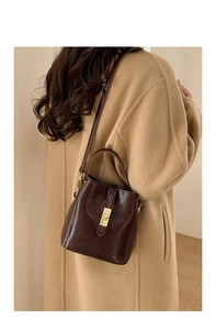 Sac seau marron foncé avec un long manteau en laine pour un look d'hiver élégant