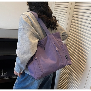 Detail view of purple large capacity tote bag with front vertical zipper pocket and side pockets