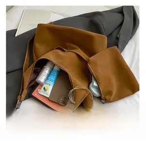 Detail view of leather tote bag interior showing spacious capacity with a matching pouch