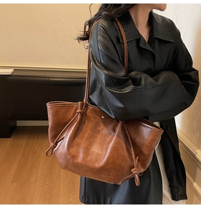 Detailed view of a brown vintage tote bag showing its large capacity and soft PU leather texture