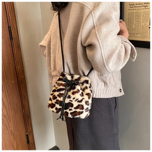 Detail of leopard print faux fur bucket bag with black leather drawstring and bow decoration