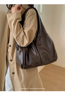 Détail du sac cabas vintage en cuir ciré avec poche latérale et ferrures sur la bandoulière