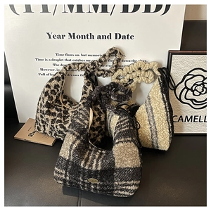 Detail view of plush faux fur tote bags in leopard and checkered patterns with ruched handles
