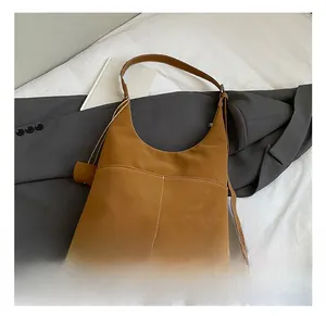 Detailed view of brown suede tote bag with contrast stitching and front double pockets