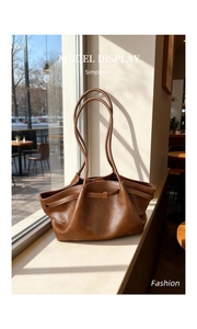 Détail du sac cabas froncé marron montrant la texture du cuir souple et les anses