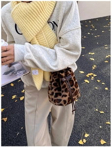 Detailed view of the soft faux fur leopard print bucket bag with drawstring closure detail