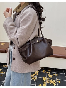 Vue détaillée du grand sac à bandoulière rétro marron foncé avec texture cuir et sangle