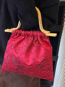 Elegant red jacquard tote bag with vintage bamboo handles and drawstring closure