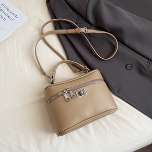 Detail of camel leather box bag with dual zippers, top handle and adjustable strap