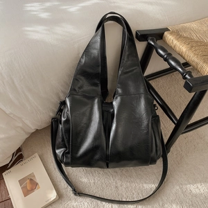 Détail du sac fourre-tout noir vintage avec texture plissée et bandoulière amovible