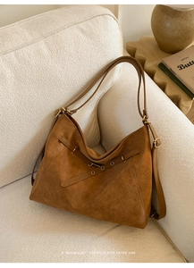 Brown woven leather tote bag with retro diamond pattern on a minimalist sofa