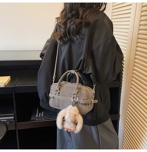 Détail du sac bandoulière gris foncé en daim avec breloque lapin et lanière