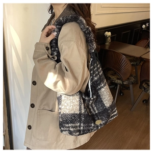 Detail of large black and white check faux fur tote bag showing plush texture and metal tag