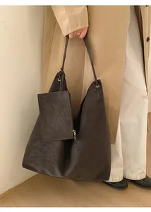 Detail of dark brown matte leather tote bag with small matching zipper pouch and shoulder strap