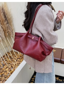 Gros plan d'un sac cabas vintage bordeaux avec texture plissée souple et fermoir métallique