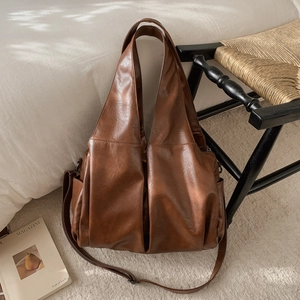 Détail d'un sac cabas vintage marron avec texture en similicuir huilé et poches latérales