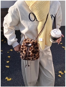 Detail of leopard print faux fur bucket bag with leather bow and drawstring closure