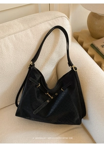 Detailed close-up of black woven texture and gold metallic buckle on a tote bag