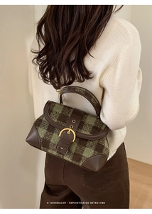 Detail of vintage green plaid tweed underarm bag with brown leather trim and gold metal buckle