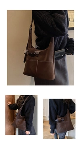 Detail of dark brown suede tote bag with contrast white stitching and small hanging pouch