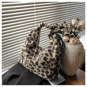 Detail of leopard print plush hobo bag with scrunchie handle and soft faux fur texture