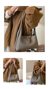 Détail d'un sac cabas en cuir gris avec boucle décorative et large bandoulière confortable