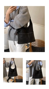 Detailed view of black hobo bag with contrast stitching and matte leather texture