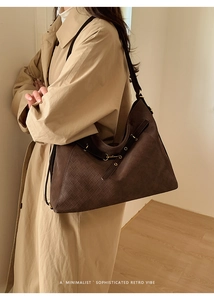 Close-up of the retro woven texture and metal buckle on this large brown leather tote bag