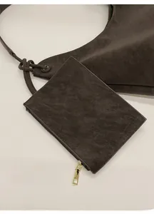 Detailed close-up of dark brown matte leather bag with golden zipper small pouch