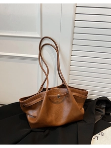 Détail d'un grand sac cabas marron en similicuir à grain litchi avec une boucle décorative