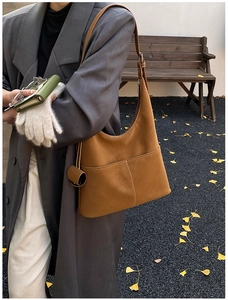 Detail view of retro caramel leather tote bag with double pockets and contrast stitching
