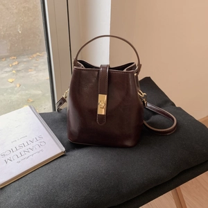 Détail d'un sac seau vintage marron foncé en cuir brillant avec fermoir doré